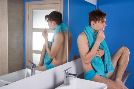 Morning. Attractive guy washing his face in the bathroom.の写真素材