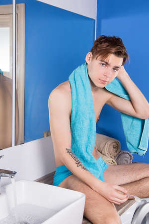 Morning. Attractive guy washing his face in the bathroom.の写真素材