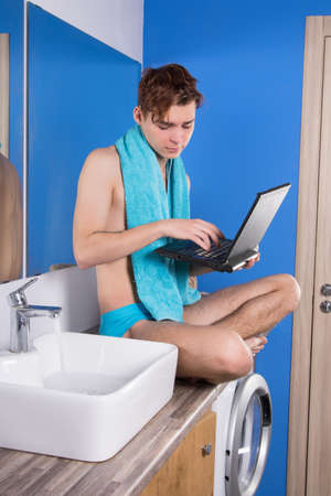 Morning. Attractive guy washing his face in the bathroom.の写真素材