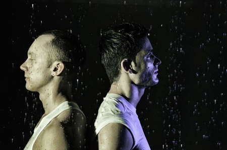 Two athletic wet guys. Love. Black background.の写真素材
