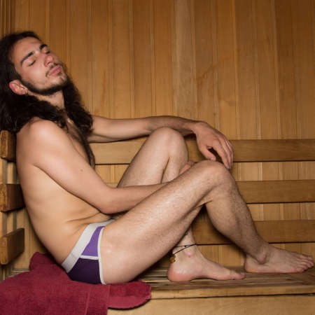 Young attractive guy is relaxing in the sauna.の写真素材