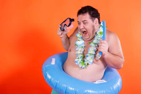 Funny fat guy and vacation. Happy man with an inflatable ring.の写真素材