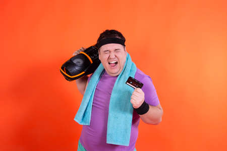 Retro style and fitness club. A funny fat man from the 80s goes in for sports.の写真素材