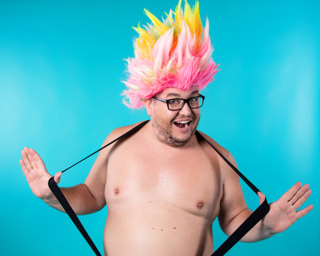 Funny fat guy with a rainbow flag. Happy man on a white background.の写真素材