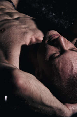 A Handsome young man under the shower dripping wet.の写真素材