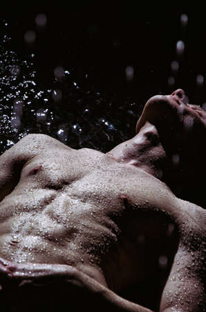 A Handsome young man under the shower dripping wet.の写真素材