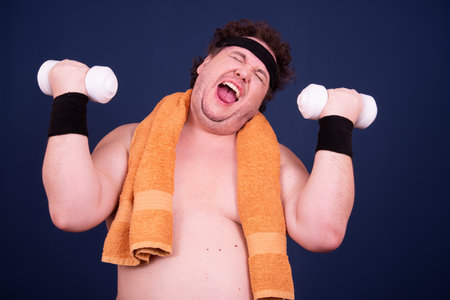 Sport, fitness and healthy lifestyle. Funny fat guy goes in for sports and eats a hamburger.の写真素材