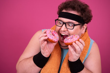 Funny fat man eats donuts. Retro style. Food and fitness.の写真素材
