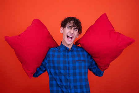 Emotions of a young attractive guy. Orange background.