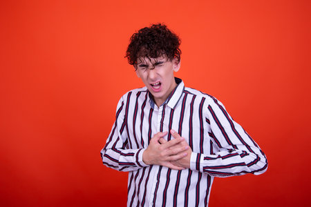 Emotions of a young attractive guy. Orange background.の写真素材