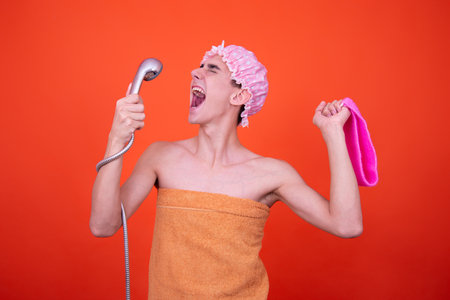 Funny guy is washing in the shower. Orange background.の写真素材