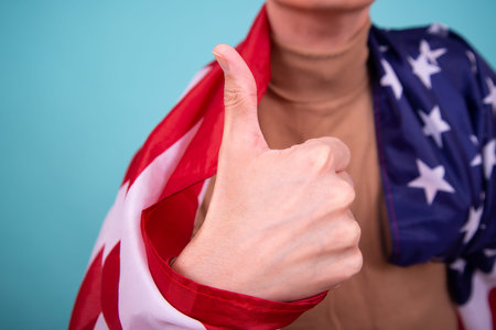 A man with a flag of the United States of America showing thumbs upの写真素材