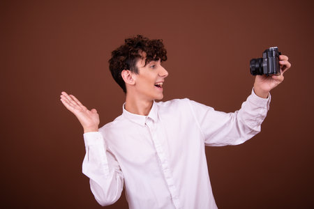 Studio shot of young handsome man against brown backgrounndの写真素材