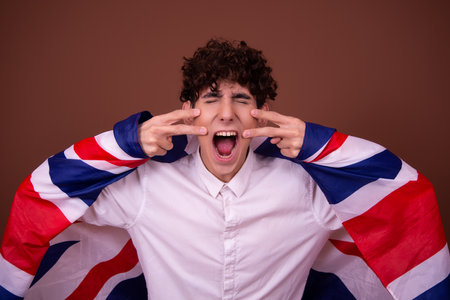 Young handsome man with curly hair against brown backgrounndの写真素材