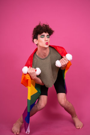 Funny girl with a rainbow flag on a pink background. The concept of LGBT.の写真素材