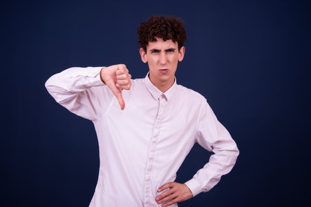 Portrait of a young man with curly hair, isolated on blue backgroundの写真素材