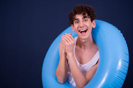 Portrait of young handsome man with curly hair against blue backround