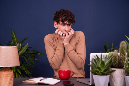 Portrait of a young man sitting at his desk in the officeの写真素材