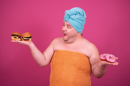 Fat man with donuts and turban isolated on pink background.の写真素材