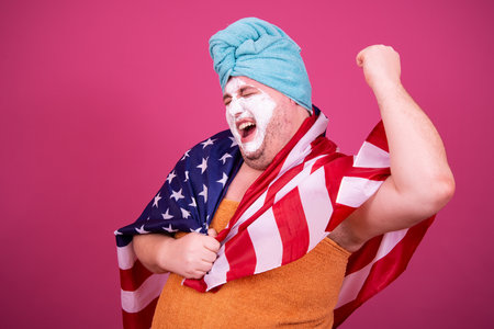 Funny man in a dressing gown and a turban on his head with an American flagの写真素材