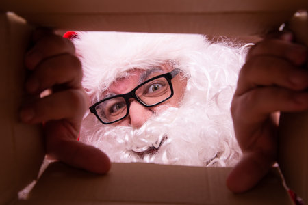 Santa Claus looking out of a cardboard box. Christmas and New Year concept.の写真素材