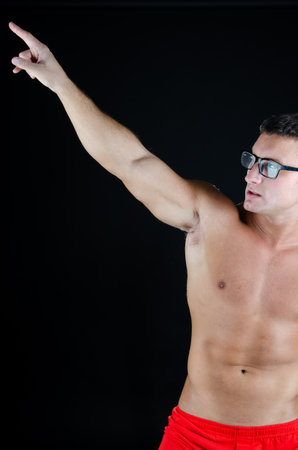 Young handsome man with athletic body posing in the studio. Sports and healthy lifestyle.の写真素材