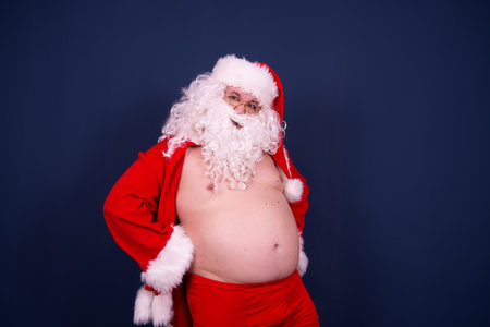 Funny fat santa is undressing.の写真素材
