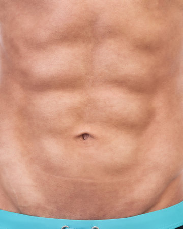 Close-up of a male torso in turquoise pants.の写真素材