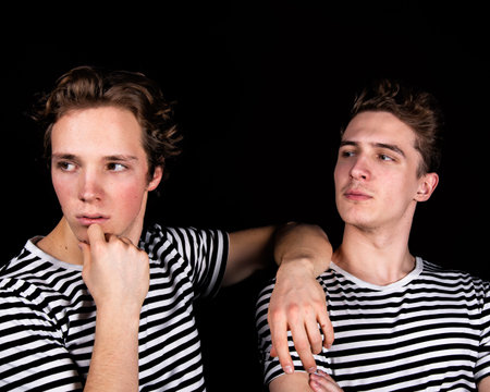 Two young people in a black and white striped shirt on a black background