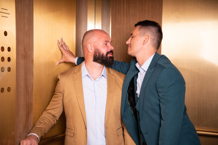 Couple flirting in an elevator. Love and relationship between two men.