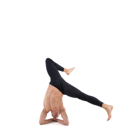 Young man doing yoga exercise. Isolated on a white background.