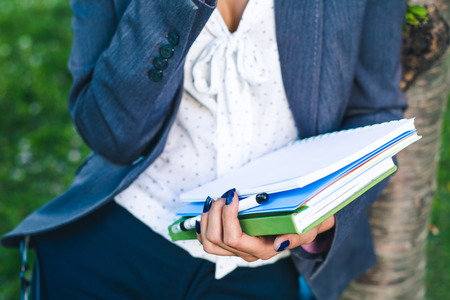 student girl with study sheets and glossary book close-up. Outdoorの写真素材