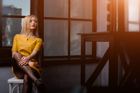 Studio shot of young and beautiful girl in yellow dress wearing in studio.の写真素材