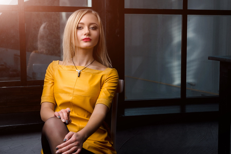 Studio shot of young and beautiful girl in yellow dress wearing in studio.の写真素材
