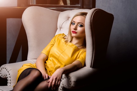 Studio shot of young and beautiful girl in yellow dress wearing in studio.の写真素材