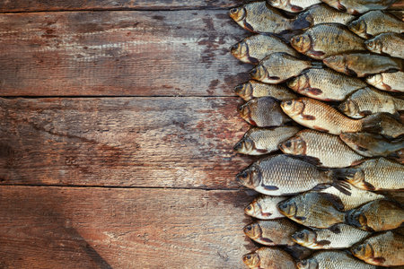 Caught carp fish on wood. Catching freshwater fish on wood background. A lot of bream fish, crucian...