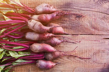Bunch of fresh organic beetroots on wooden rustic table. A half of a wooden table is free for the...