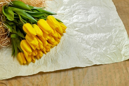 Fresh flower composition, bouquet yellow tulips on craft paper backgroundの写真素材