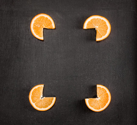 Frame from slices of orange. Space for text. Top view. Black background