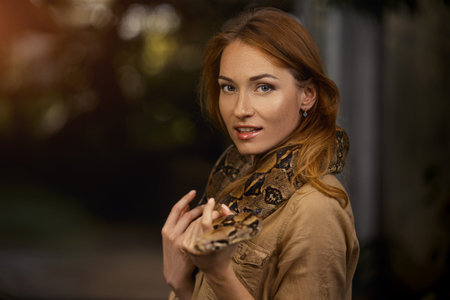 Beautiful girl with a python on the shoulders