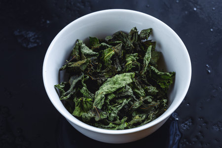 Dried leaves Mint or melisa or Basil or other herbs in Plate on black background