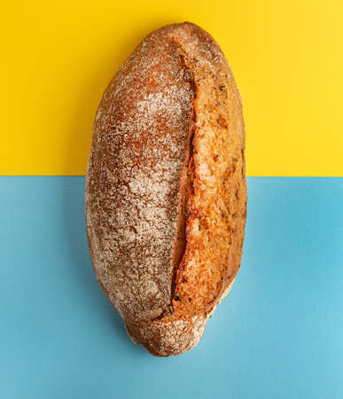 Ukrainian bread on blue and yellow flag background. Loaves on bread on abstrackt Ukrainian background. Russia blockade Ukrainian grainの写真素材