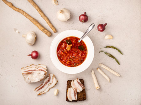 Traditional Ukrainian borsch, made from red beets, cabbage, and meat. A plate of Ukrainian folk dish, with Ukrainian lard, horseradish root, garlic, onions, and peppers. The view from the top.の写真素材