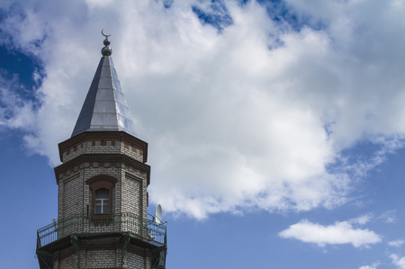 Mosque of Sunni Muslims. Minaret against the blue sky with white clouds.の写真素材