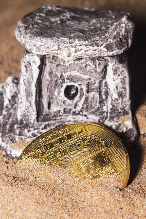 Crypto currency bitcoin in the sand near the ancient temple.の写真素材