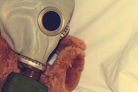 A toy in a gas mask as a concept for protecting children from the use of gas weapons, environmental pollution and the International Day of Remembrance for the Victims of the Chernobyl Catastrophe.の写真素材