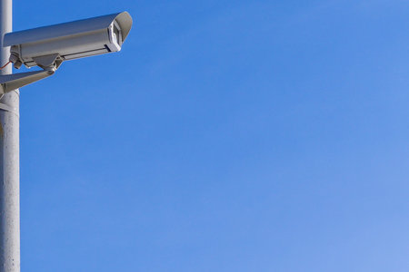 Security camera against the blue sky are monitoring. The image has a copy space.