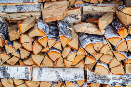 A lot of chopped firewood lies in a woodpile as fuel for a stove or fireplace. Rural life or forest...