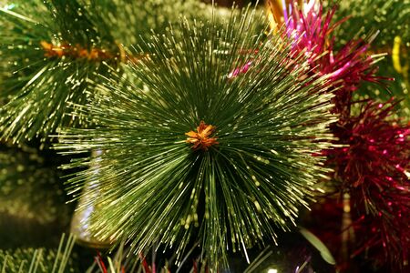 Bright and shiny decorations for Christmas and New Year hang on a green spruce. Winter holidays.の写真素材