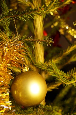 Bright and shiny decorations for Christmas and New Year hang on a green spruce. Winter holidays.の写真素材